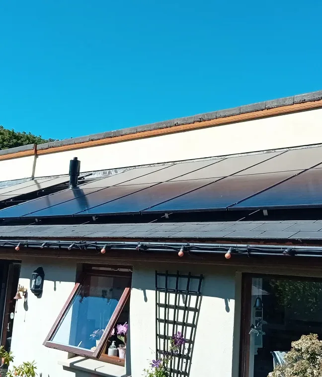 Solar panels on a bungalow roof under clear blue sky