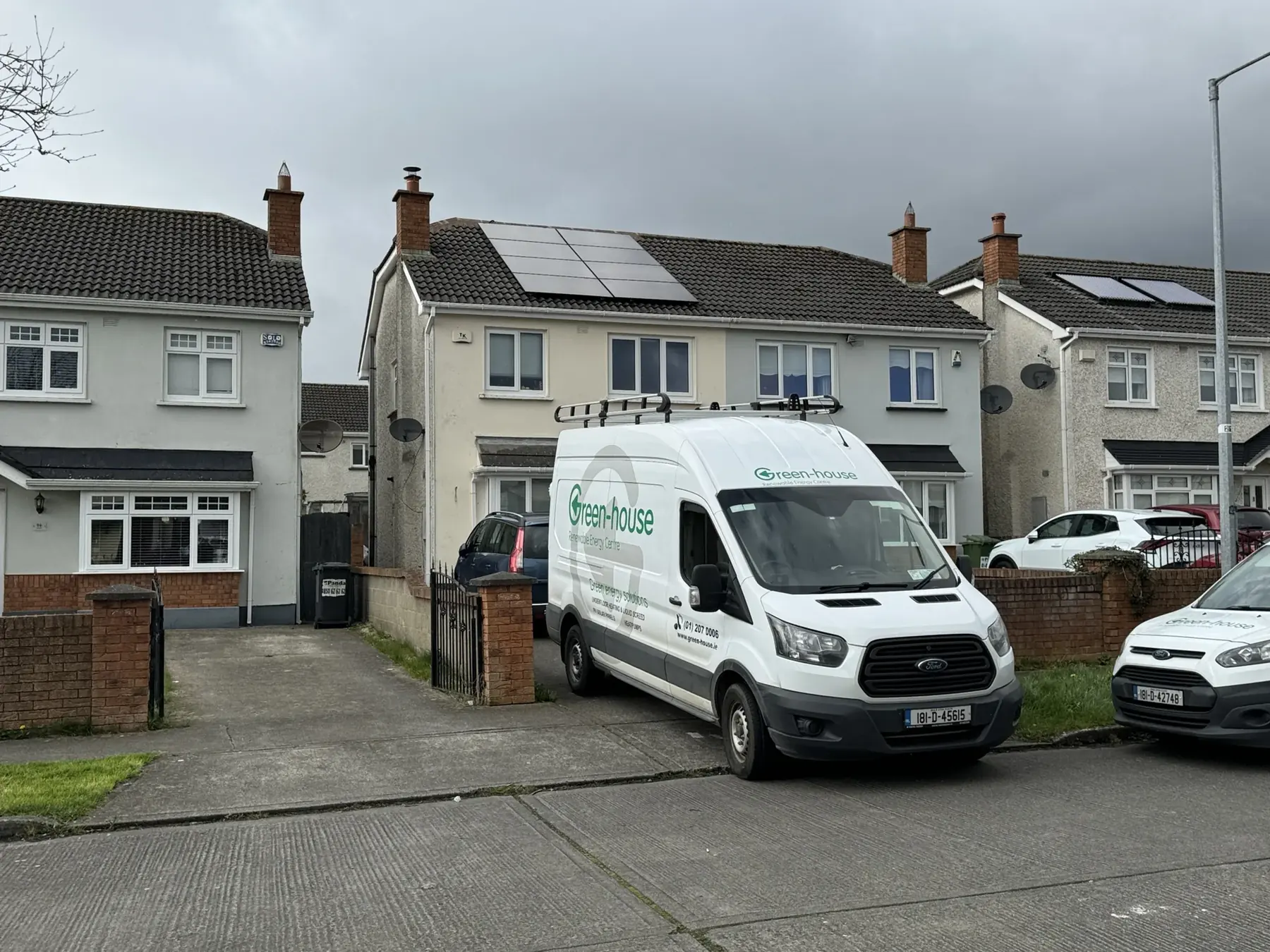 Two Green-house Solar Energy vans outside a Dublin home with solar panels newly fitted to the roof