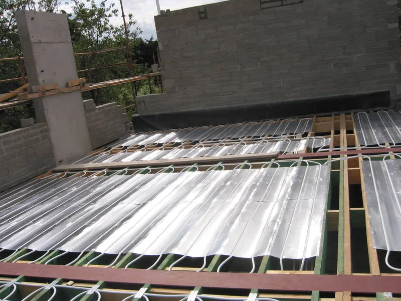 Aluminium heat deflector trays laid between joists before the pipe is run